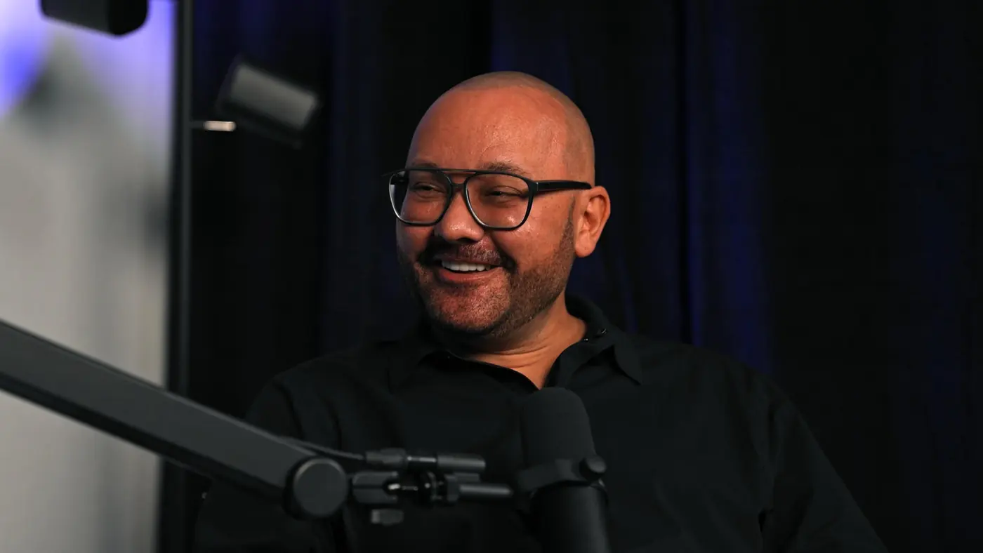 Gast lacht bei der Aufnahme des Hello Hair Podcasts vor violettem Studiohintergrund